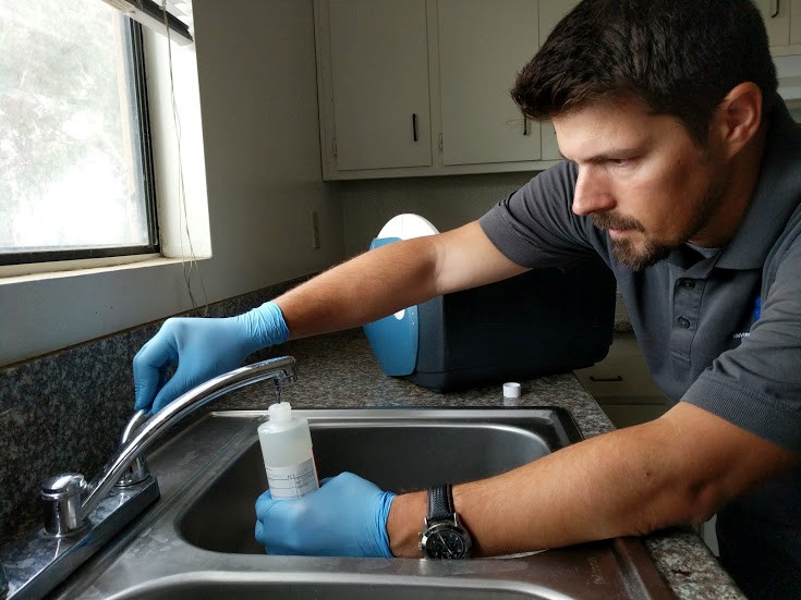 An image of a Citadel Employee taking a water sample at a private residence as part of AB 2370 Lead Testing and Prevention 