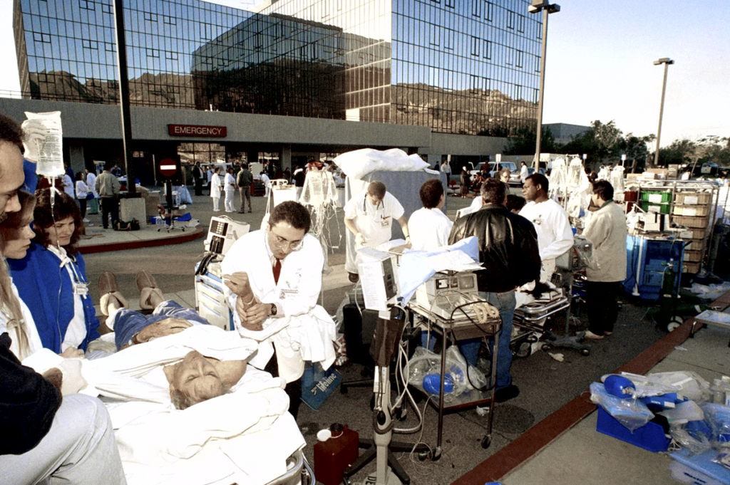 A picture of a hospital after the 1994 Northridge earthquake, with doctors tending to patients outside in the parting area. California passed into law seismic retrofitting requirements. This law requires hospital buildings to remain fully operational following a quake, with a deadline of 2030. Currently, 258 of 414 hospitals have at least one building yet to meet this set of standards. Additional requirements for a variety of building types in addition to hospitals have been added in the intervening nearly 30 years.